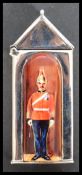 A sterling silver vesta case in the form of a sentry box with enamel panel depicting a guard. Weighs