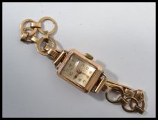 A 9ct gold hallmarked hallmarked cased Dominant 15 jewel ladies cocktail watch on a 9ct gold