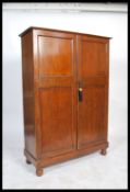 Holdall - A 1930's oak compactum wardrobe having a haberdashery style appointed interior and twin