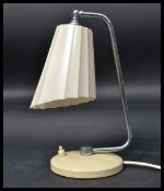A 1940's art deco vintage Bauhaus style desk lamp having a cream terraced base on a polished steel