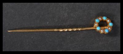 An early 20th century 15ct gold turquoise and pearl stick pin. Weight 1.5g. Marked 15ct tests 15ct