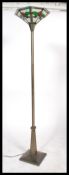 A contemporary Tiffany leaded and stained glass standard lamp uplighter. The terraced base and