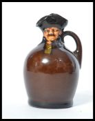 A Royal Doulton Kingsware flask flagon jug bottle having a night watchman Toby top. Marks to base.