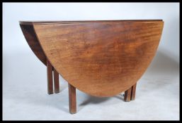 A 19th century Georgian large mahogany drop leaf dining table being raised on squared legs having