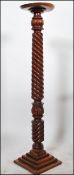 A 19th century Victorian barley twist carved wooden torchere plant stand raised on a quadruped