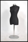 A vintage 20th century shop haberdashery tailor's dummy raised on a plinth base with a black
