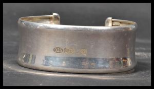 A hallmarked silver bangle bracelet of typical form having an open back with large Sheffield rose