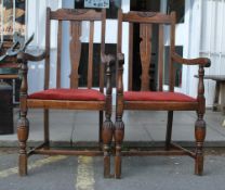 A pair of 1920's solid oak carver armchairs - dining chairs. raised on block legs with cup and cover