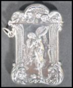 A sterling silver vesta case of scrolled form having relief decoration of a nude fairy. Weighs 38