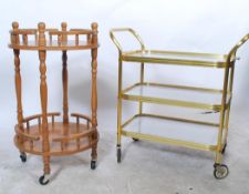 Two vintage 20th century cocktail bar drinks trolleys to include a circular wooden example and a