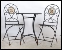 A vintage style mosaic topped bistro table and two chairs, the metal framed set having a metamorphic