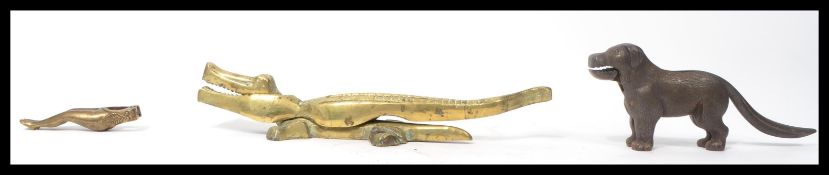 A group of three vintage 20th century cast metal nutcrackers. One brass example in the form of a