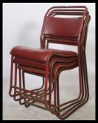 A set of 4 mid century tubular metal stacking chairs in the original burgandy red painted finish.