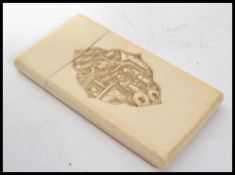 A 19th century Cantonese ivory calling card case hand carved with traditional scenes with plain