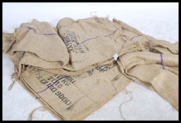 A large collection of vintage 20th century Industrial Hessian sacks, each with remains of notations.