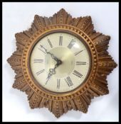 A vintage mid 20th century retro Smiths sunburst wall clock. The two tone dial having Roman numerals
