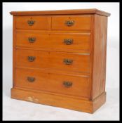 An Edwardian two over three pale mahogany chest of drawers having a flat and flared top with brass