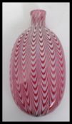 A Victorian 19th century Nailsea glass flat oval bottle in cranberry with white spiralling twist