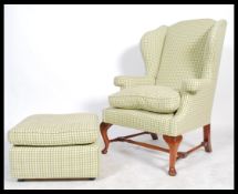 An antique style large Georgian revival wingback armchair and footstool ottoman, Both upholstered in