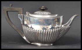 An early 20th century silver hallmarked bachelors teapot of oval form with half reeded decoration by