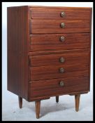 A retro 1970's Danish influenced chest of drawers being raised on tapering turned legs with a bank