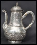 A continental silver hallmarked tea pot having a bulbous body decorated with scrolls and relief