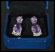 A pair of sterling silver and amethyst drop earrin