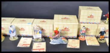 A collection of seven boxed Royal Doulton Rupert The Bear figures to include Edward Trunk pretending