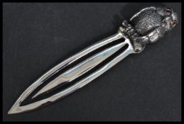 A sterling silver bookmark having a bird finial handle with inset ruby eyes. Weighs 10 grams.