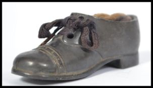 A 19th century Victorian bronze pin cushion in the form of a boot with string laces.