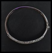 A sterling silver and CZ bangle bracelet having two lined of white CZ stones with hidden clip