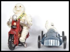 A pair of transport interest advertising cast metal figures of the Michelin man, one on a red
