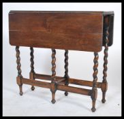 A 1920's barley  twist oak drop leaf dining table having squared leaves with barleytwist supports