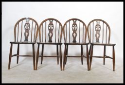 A set of four vintage mid 20th Century Ercol hoop back beech and elm dining chairs. Fleur De Lys