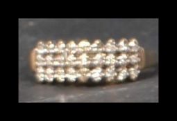 A hallmarked 9ct gold and diamond ring having 27 prong set diamonds in pointed domed setting.