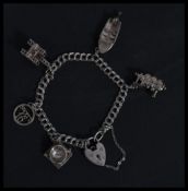 A hallmarked 925 silver charm bracelet having charms to include articulating speed boat, oil rig,