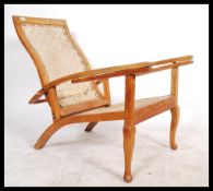 A 20th Century vintage hardwood Plantation chair / armchair with 2 slide out arms being raise on