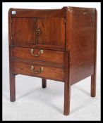 An early 19th century Georgian mahogany bedside being gallery tray top with twin door cupboard above