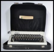 A vintage mid century portable Erica typewriter, cased within it's original black carry case with