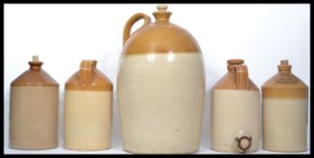 A collection of five vintage early 20th century stoneware flagons to include a very tall one with