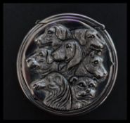 A silver plated vesta case of circular form having relief decoration depicting the dogs from