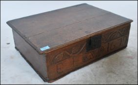 A 17th century Restoration period carved oak bible box having hand carved scroll and leaf decoration