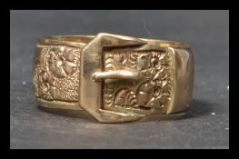 A hallmarked 9ct gold band ring in the form of a buckle having diamond cut foliates to band.