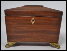 A good Georgian 19th century mahogany tea caddy of sarcophagus form having brass hairy paw feet with