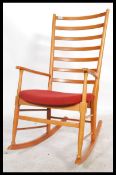 A vintage 20th century Danish Scandart rocking chair having rail back rest with shaped elbow