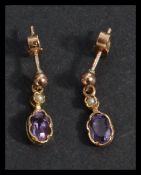 A pair of hallmarked 9ct gold earrings set with amethyst stones and seed pearl. Hallmarked London.
