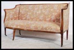 A Georgian early 19th century conversation sofa. Raised on turned legs with castors having an