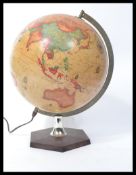 A retro 20th century illuminated terrestrial desk top globe raised on a pedestal base, the globe
