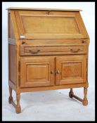 A 20th century French oak bureau being raised on turned legs with fall front bureau having appointed