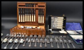 A vintage 20th century oak cased canteen of cutlery together with cased flatware to include a
